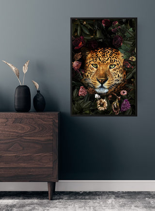 Leopard with flowers poster hanging on a dark wall above a wooden dresser in a modern room.