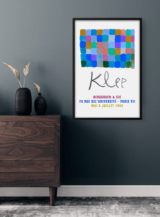 Framed Paul Klee Blue Exhibition 1955 Plakat on a dark wall above a wooden dresser with vases.