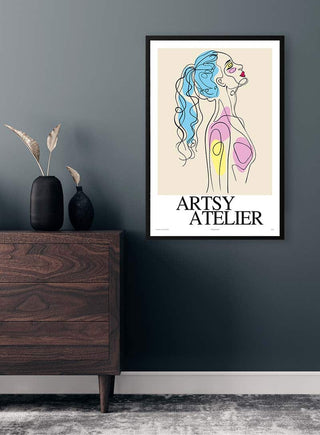 Abstract woman line art poster with colorful accents, framed and hung on a modern wall above a wooden dresser.