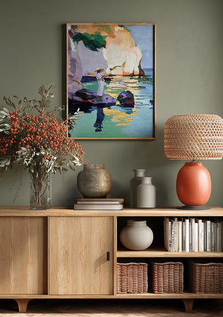 Woman by the Cliffs by Elena Avanesova above a wooden sideboard on a sage green wall