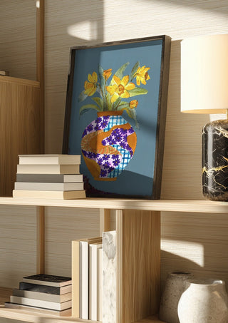 Narcissus by Marjorie Salvagni in a dark frame on a wooden shelf beside books and a lamp