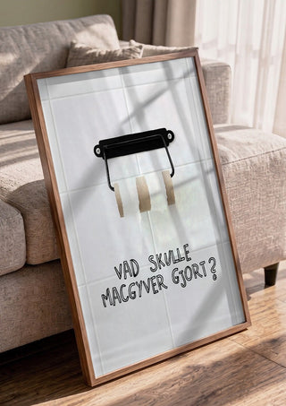 Vad skulle Macgyver gjort? by Grafik bageri in a walnut frame leaning against a grey sofa