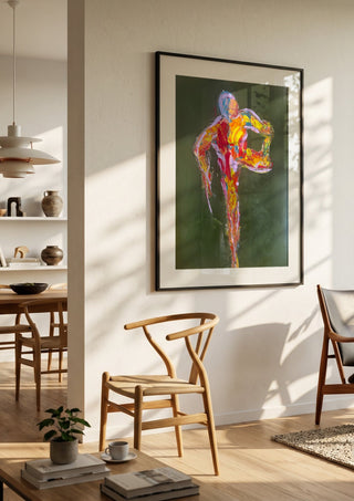Figure in Motion by René J in a black frame in a bright dining room with wooden chairs
