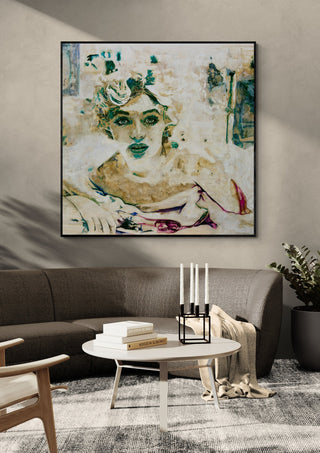 Norma by Mushk in a black frame above a grey sofa with a round coffee table and candlesticks