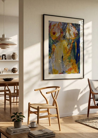 Torso in Yellow by René J in a black frame in a bright dining room with wooden chairs