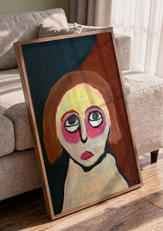 Kreativ by RR in a walnut frame leaning against a grey sofa