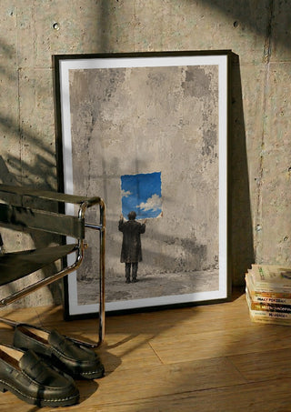 Borrowed Sky by Matthews Gallerie in a black frame leaning against a concrete wall by a steel chair