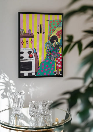 Afternoon with the Cat by Camilla Nilsson in a black frame above a glass table with crystal glassware