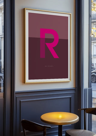 R as in Rebel – Cerise by Quite Nice Prints in an oak frame on a panelled cafe wall