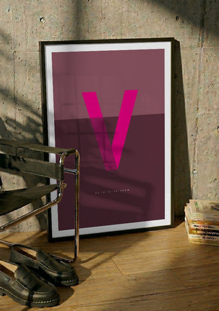 V as in Va-va-voom – Cerise by Quite Nice Prints in a black frame leaning against a concrete wall by a steel chair