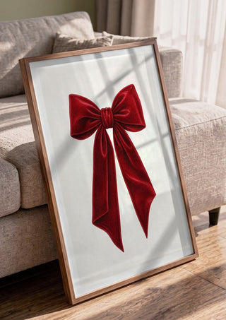 Red velvet bow by Ohkimiko in a walnut frame leaning against a grey sofa
