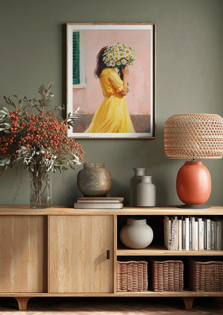 Girl in yellow dress with flowers by Ohkimiko above a wooden sideboard on a sage green wall