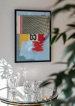 No.65 by Kareem Rizk in a black frame above a glass table with crystal glassware