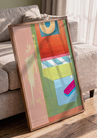 Bubble Gum by Kareem Rizk in a walnut frame leaning against a grey sofa