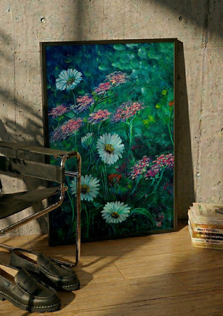 White Daisies and Yarrow by Svetla Stoyanova Bassi in a black frame leaning against a concrete wall by a steel chair