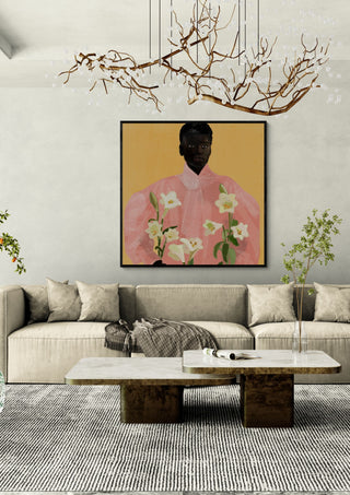 Girl Holding Flowers 2 by ThingDesign in a black frame above a cream sofa under a branch chandelier