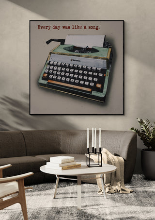 Like a Song by Carl Smith ART in a black frame above a curved grey sofa with candlesticks on a round table