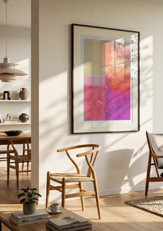 soft atmospheric composition by Iris Lehnhardt in a black frame in a bright dining room with wooden chairs