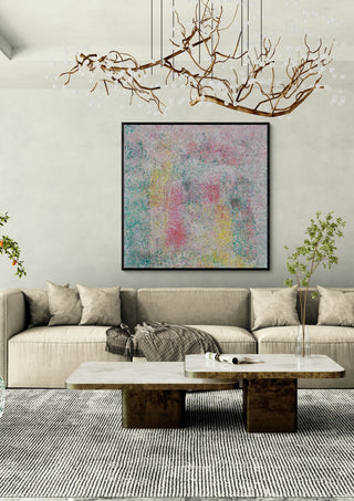 Between dream and light by Marcel Herrmann in a black frame above a cream sofa under a branch chandelier