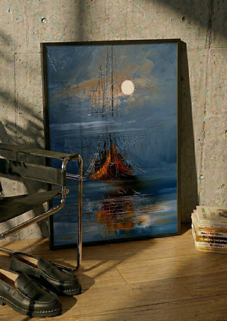 Moon over the Ship by Justyna Kopania in a black frame leaning against a concrete wall by a steel chair