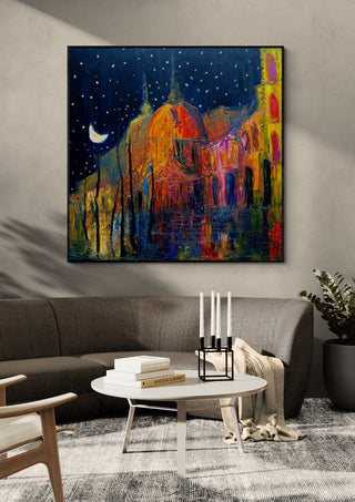 Crescent over the Domes by Justyna Kopania in a black frame above a dark sofa with candlesticks on a round table