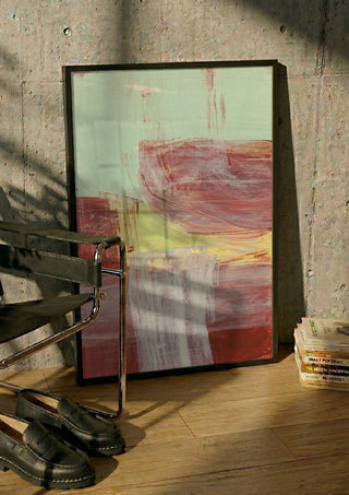 abstract layers and forms 1 by Iris Lehnhardt in a black frame leaning against a concrete wall by a steel chair