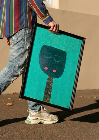 Pricken by RR carried in a black frame along a sunny street