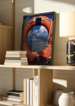 Three Layers of Presence by Bora Kőhalmi in a dark frame on a wooden shelf beside books and a lamp