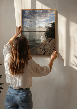 Sunset at the Lakeside Dock by Bora Kőhalmi being hung on a sunlit wall
