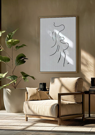 I am move by FridaRit framed above a beige armchair beside a potted plant