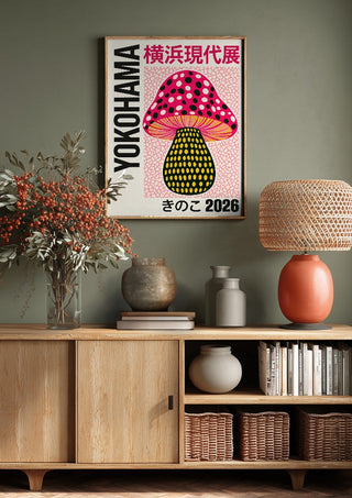 Pink Dot Mushroom Poster by Yokohama above a wooden sideboard on a sage green wall