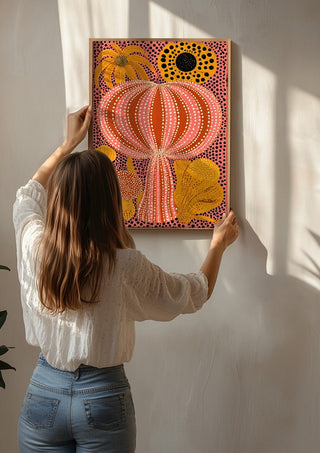 Pink Dotted Pumpkin by Yokohama being hung on a sunlit wall