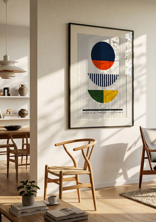 Bauhaus Circles by Neil Stevens in a black frame in a bright dining room with wooden chairs