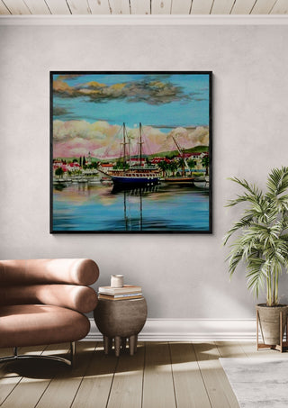 Nice City by Sunny in a black frame above a pink armchair beside a potted palm