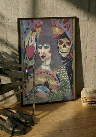 Mujer y muerte by Carlos Enrique Gozalo Ara in a black frame leaning against a concrete wall by a steel chair