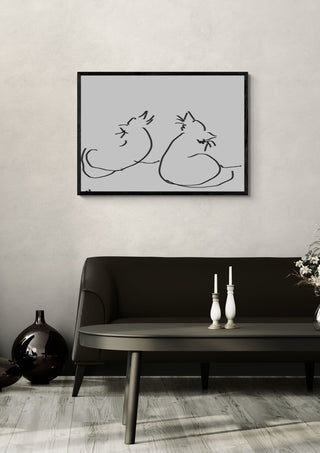 Two Cats by Eva Hartman in a black frame above a dark sofa with candlesticks