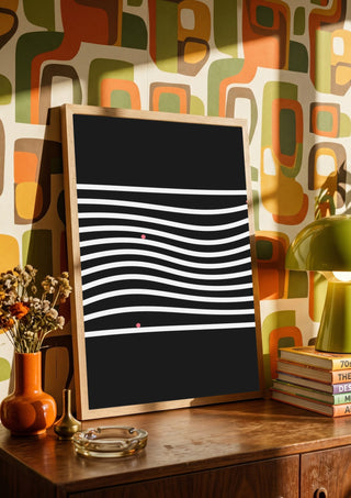 Marbels by Aleksi Allan in a wooden frame on a sideboard against a retro patterned wall