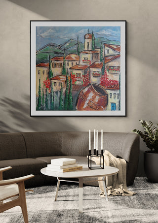 Cyprus village by Dina in a black frame above a grey sofa with candlesticks