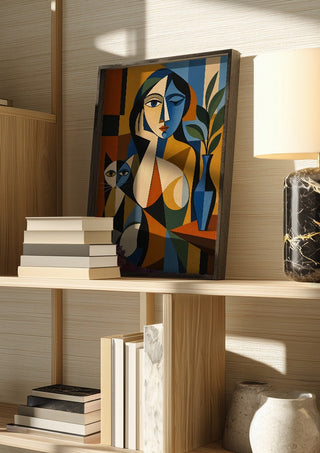 Cubist Woman with Cat and Vase by TimlessArtworks in a dark frame on a wooden shelf beside books and a lamp