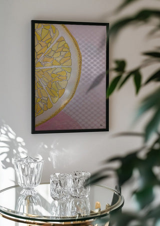 Lemon Slice by L.OE. Art in a black frame above a glass table with crystal glassware