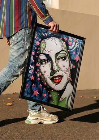 StarLady by Okiana carried in a black frame along a sunny street