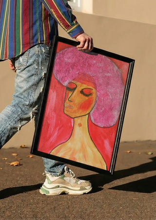 woman with a birthmark by Ian Frederick Harris carried in a black frame along a sunny street