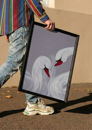 The Swirl of Us by Bibi carried in a black frame along a sunny street