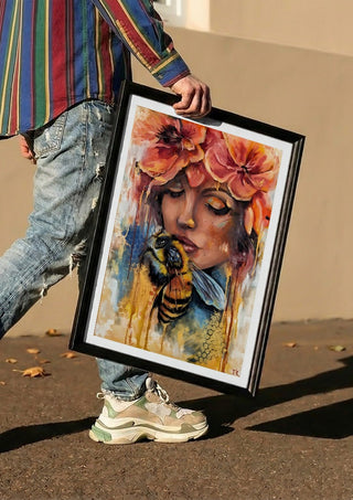 BeeYou by Elisa Kay carried in a black frame along a sunny street