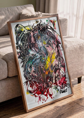 Tangle by Ronald Rumell in a walnut frame leaning against a grey sofa