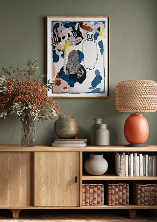 I CRACKED THE BED, THE GHOST WAS UNDER by Oscar Birch above a wooden sideboard on a sage green wall