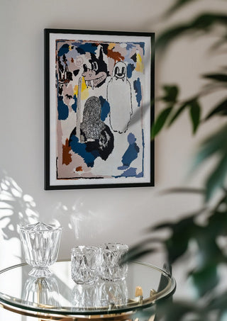 I CRACKED THE BED, THE GHOST WAS UNDER by Oscar Birch in a black frame above a glass table with crystal glassware