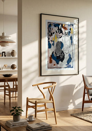 I CRACKED THE BED, THE GHOST WAS UNDER by Oscar Birch in a black frame in a bright dining room with wooden chairs