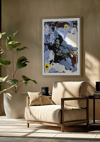 LOVE IS A DOG FROM HELL by Oscar Birch framed above a beige armchair beside a potted plant