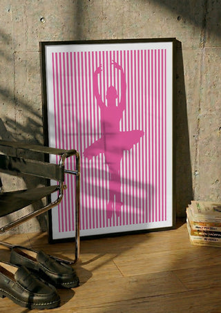 Ballerina silhouette by nyai in a black frame leaning against a concrete wall by a steel chair